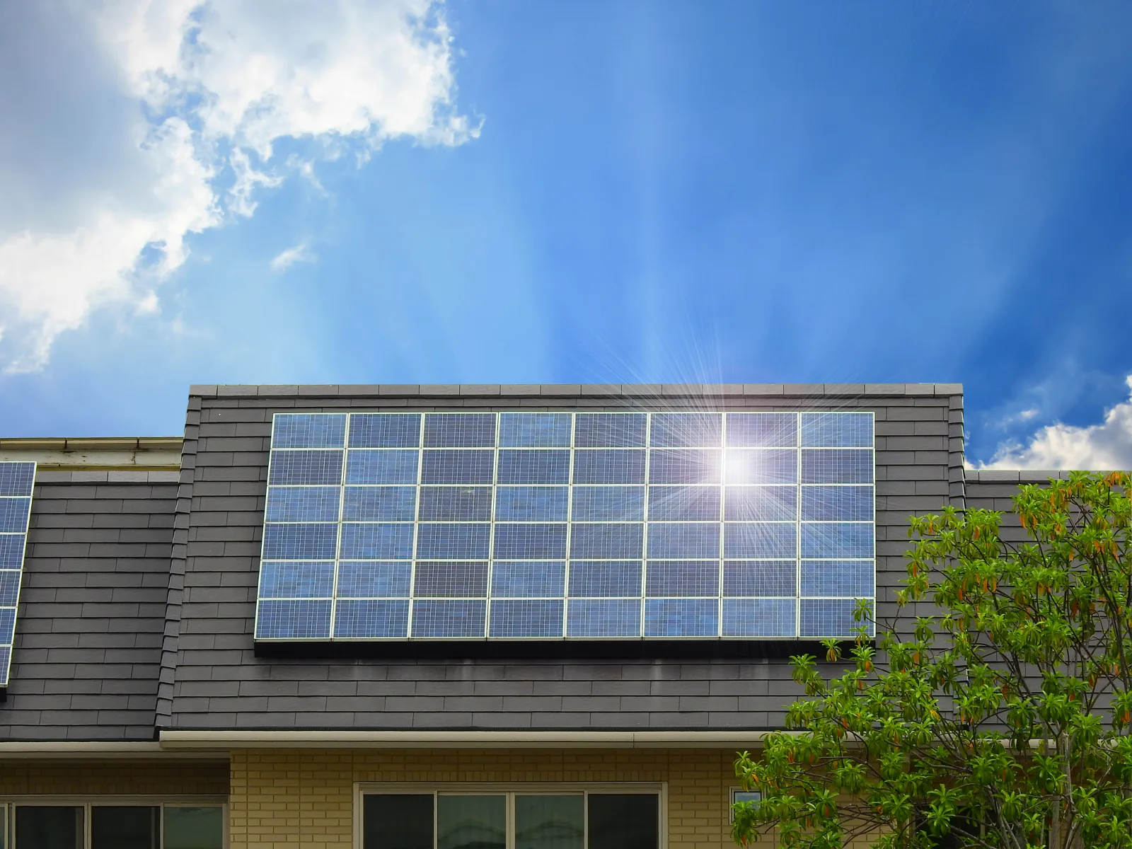 Solar panels fitted neatly to a house under a blue sky